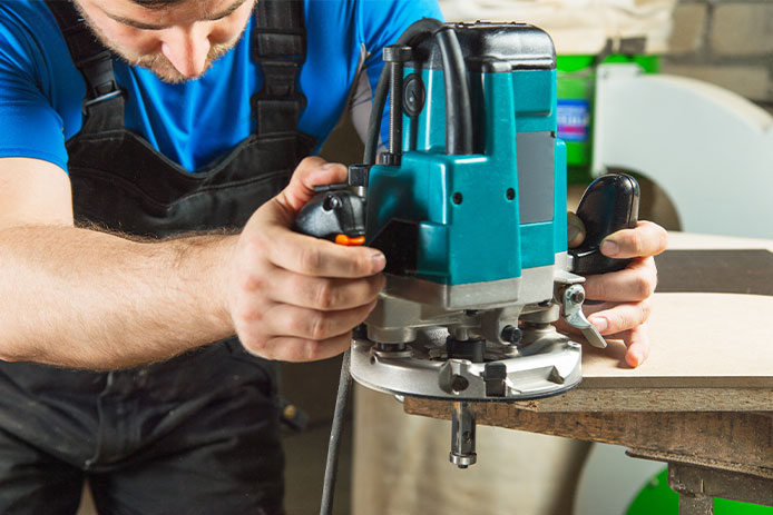 A man using a plunge base router