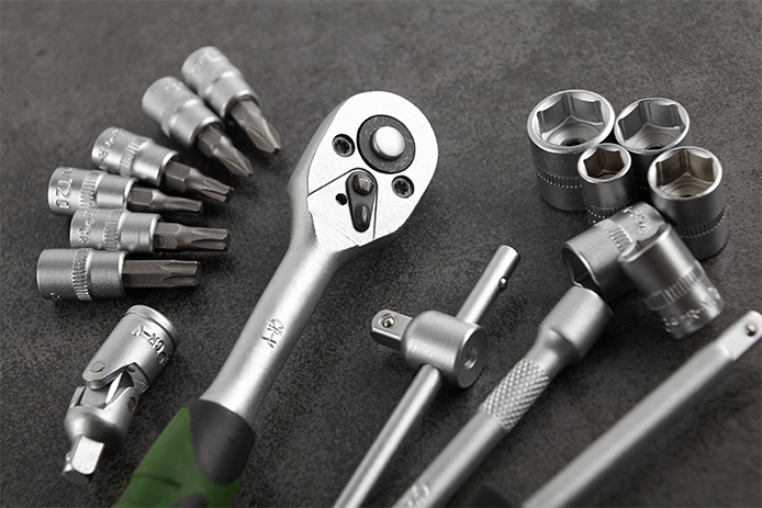 A basic silver-colored socket set is shown against a dark, charcoal-colored background.